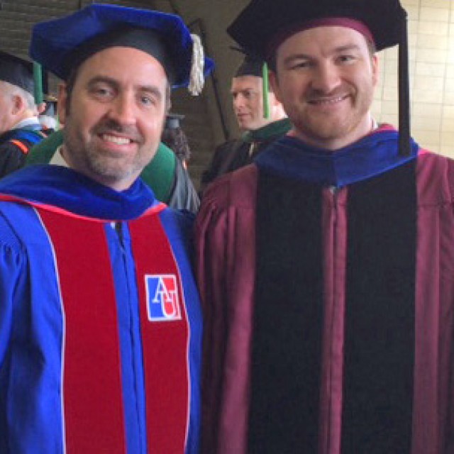 Eric Vallender, wearing his UChicago gown, with a colleague at a University of Mississippi Commencement ceremony.
